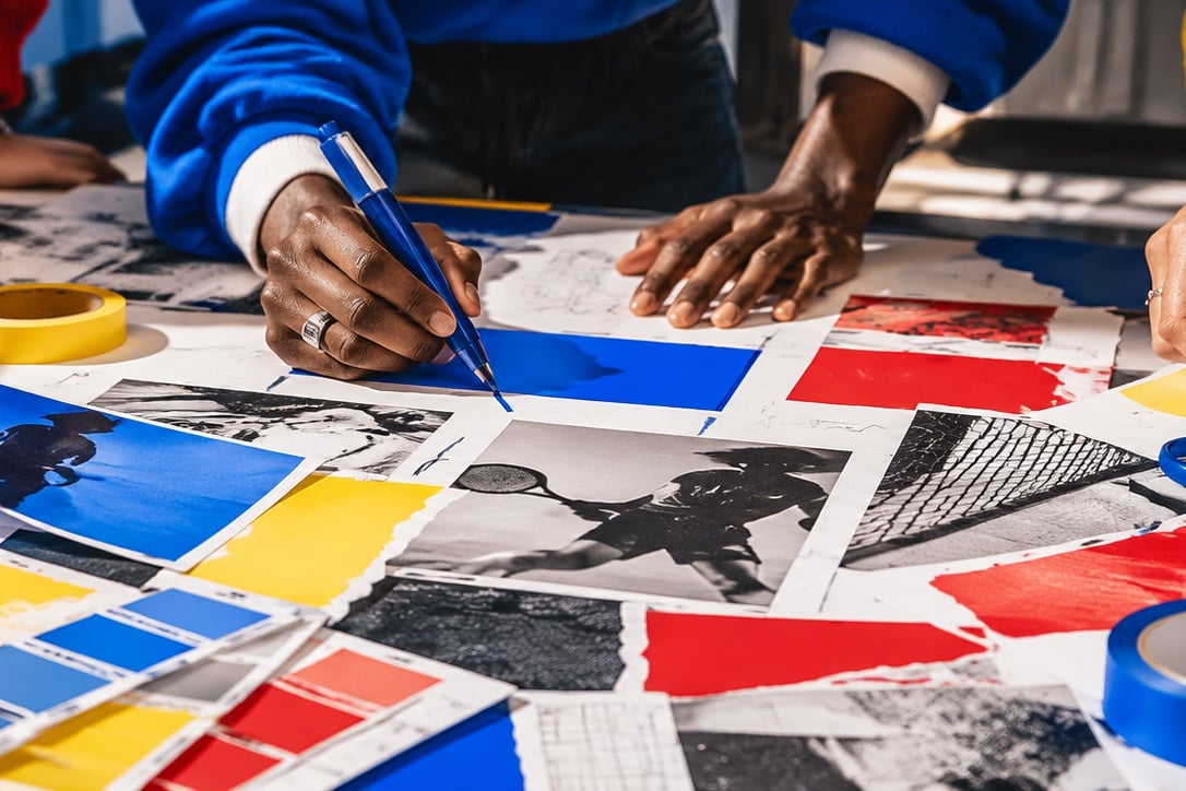 Fotografía conceptual: manos trabajando sobre impresos y muestras en colores primarios